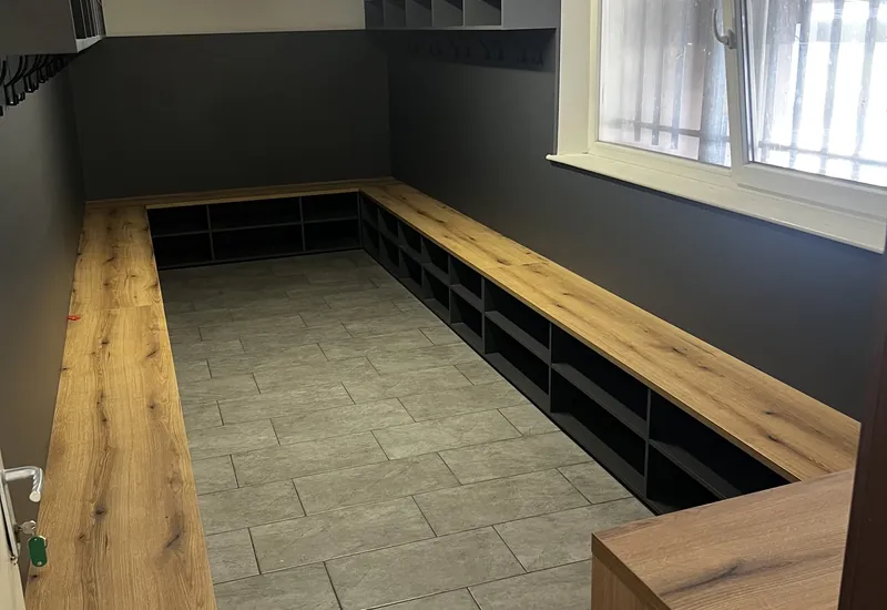 Futbalová šatňa s dubovo-čiernymi šatňovými boxmi a lavicami