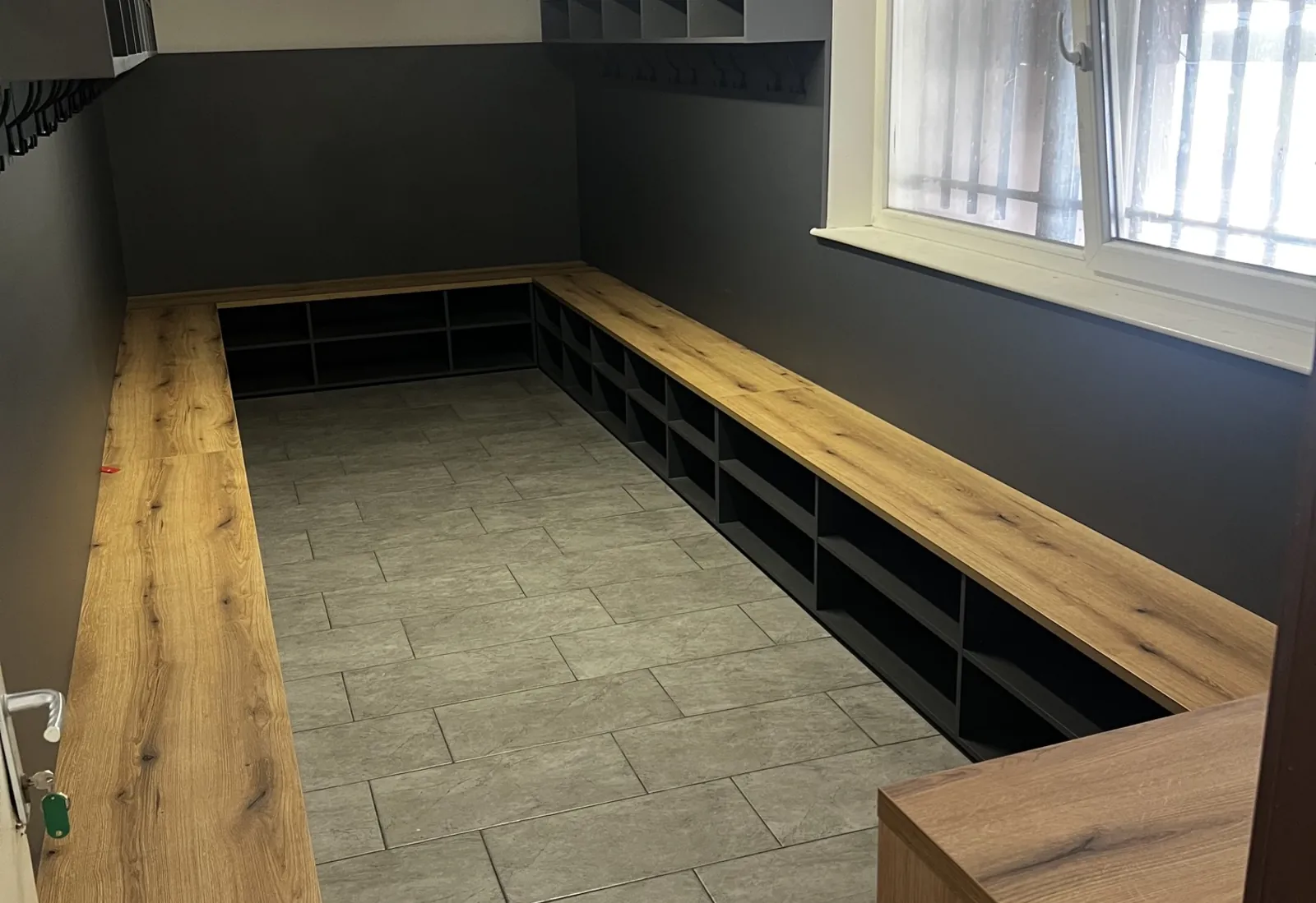 Futbalová šatňa s dubovo-čiernymi šatňovými boxmi a lavicami