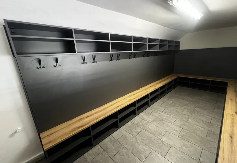 Futbalová šatňa s dubovo-čiernymi šatňovými boxmi a lavicami